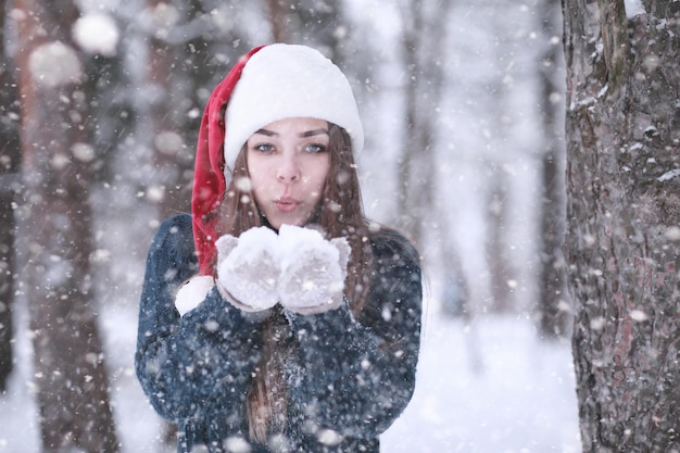 Chica en un parque de invierno por la tarde en nevadas