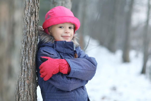 Chica en el paseo de la nieve del invierno del parque