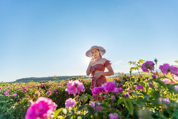 Chica en paseos en una plantación de rosas