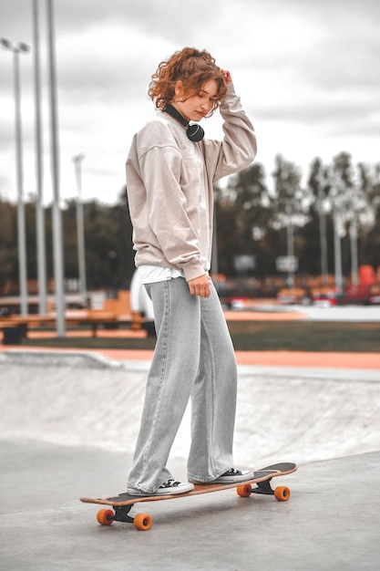 Chica en patineta en el parque por la tarde