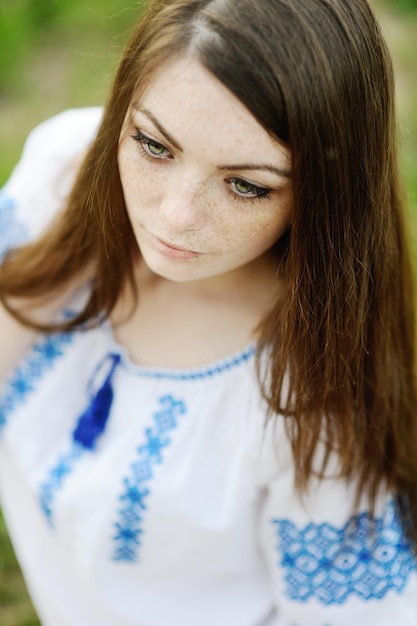 Chica con pecas en la cara con una camisa ucraniana