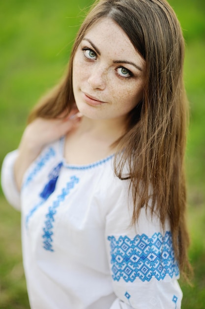 Chica con pecas en la cara con una camisa ucraniana