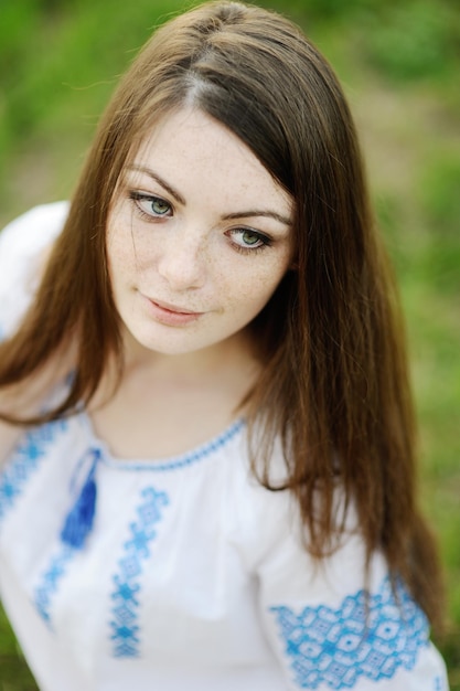 Chica con pecas en la cara con una camisa ucraniana