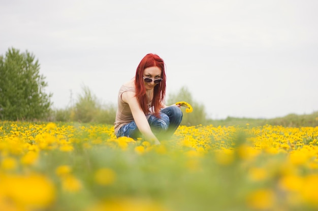 Chica pelirroja en el campo de los dientes de león, borrosa