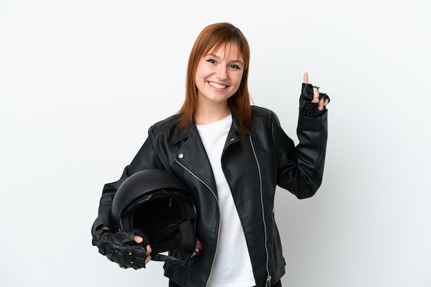 Chica pelirroja con un casco de motocicleta aislado sobre fondo blanco apuntando a una gran idea