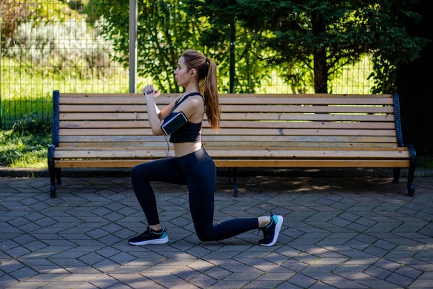 Chica pelirroja deportiva con ropa deportiva durante el entrenamiento en el parque. Encajar en la naturaleza en la mañana del día de otoño