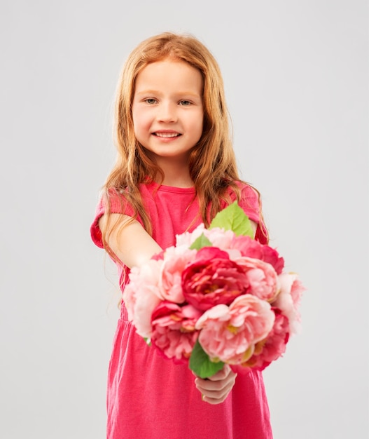 una chica pelirroja feliz con flores