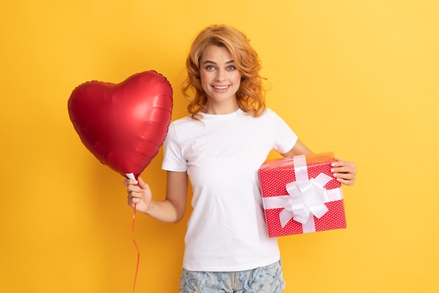 Chica pelirroja feliz con globo de corazón de amor y caja feliz día de san valentín