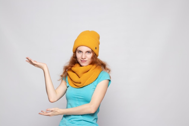 Chica pelirroja en un gorro sobre un fondo claro