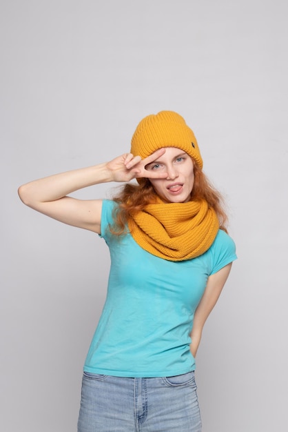 Foto chica pelirroja en un gorro sobre un fondo claro