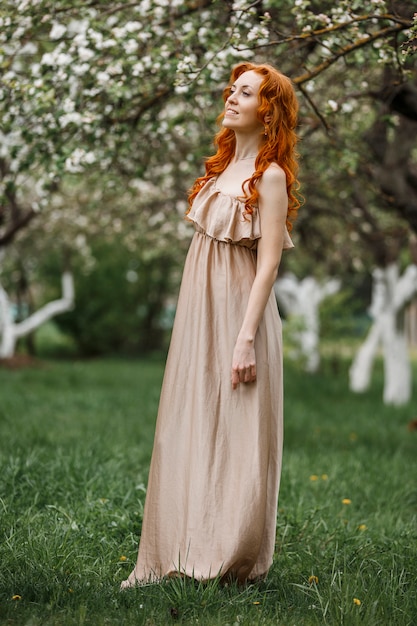 Chica pelirroja en un jardín floreciente