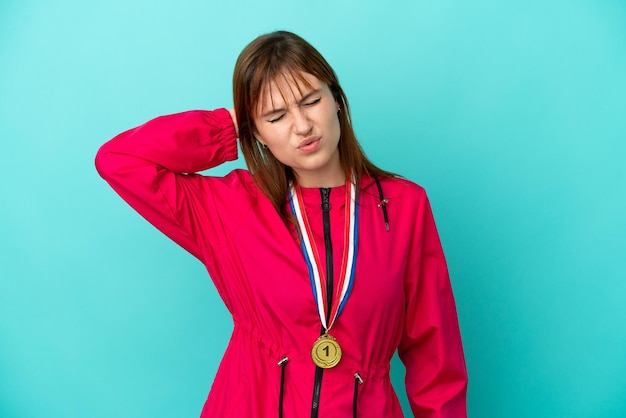 Chica pelirroja con medallas aislado o fondo azul con dolor de cuello