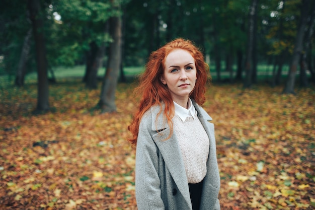 chica pelirroja en el parque de otoño