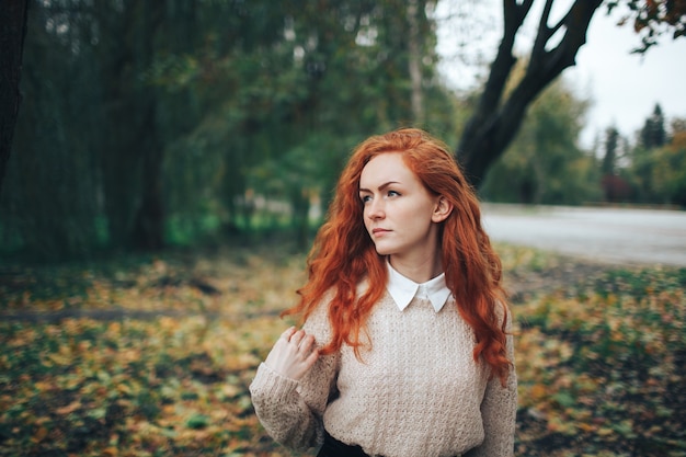 chica pelirroja en el parque de otoño