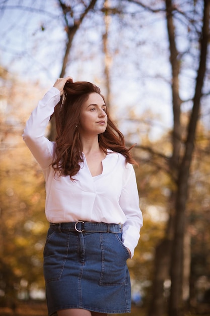 Chica pelirroja en retrato de follaje de otoño