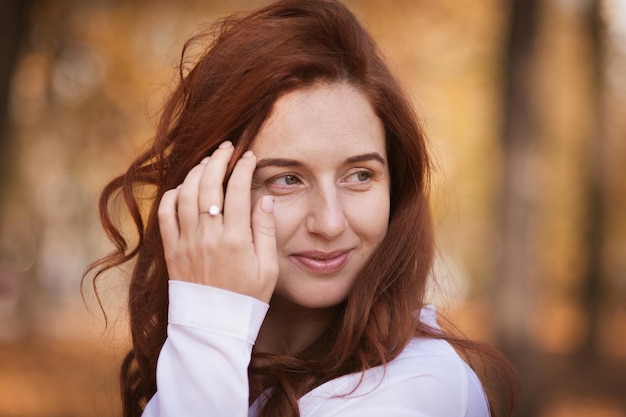 Chica pelirroja en retrato de follaje de otoño