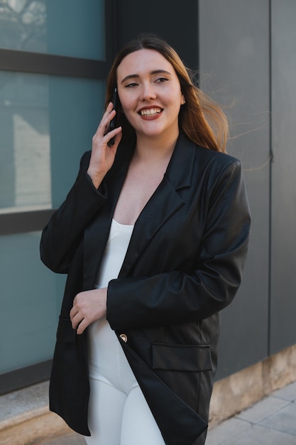 Chica pelirroja sonriendo mientras habla por teléfono