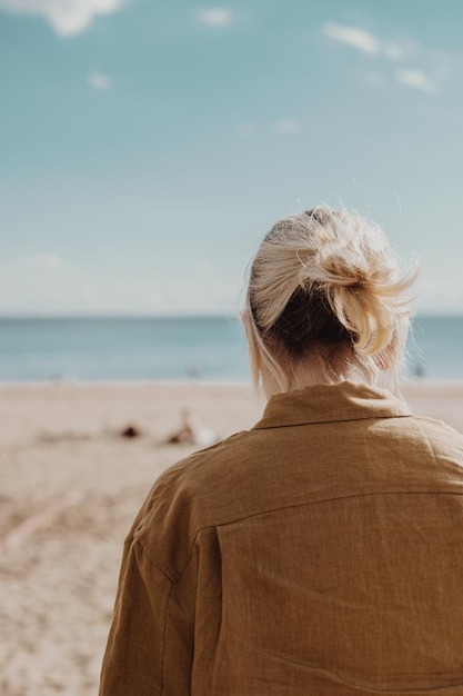 Chica con pelo corto sentada en la playa