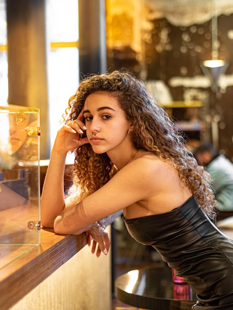 CHICA PELO CURLY EN RESTAURANTE CON VESTIDO NEGRO