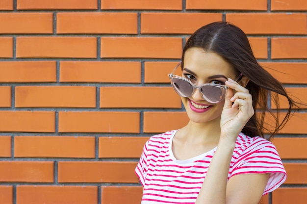 Una chica con el pelo largo y castaño con una camiseta a rayas roja y blanca.