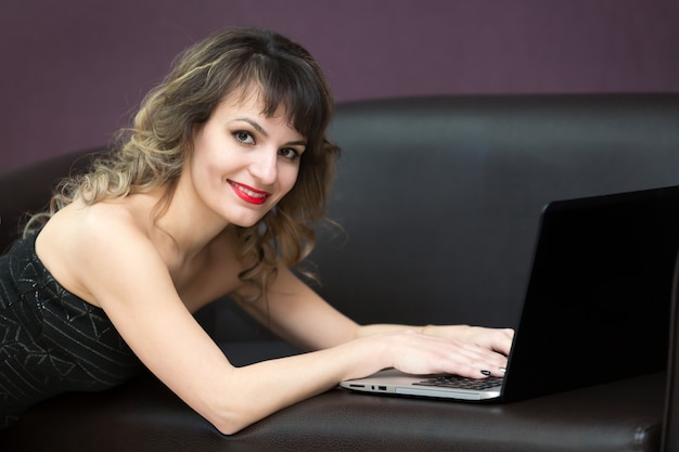 Chica con el pelo largo con un ordenador portátil.