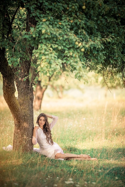 Chica de pelo largo con un vestido viejo en el jardín.