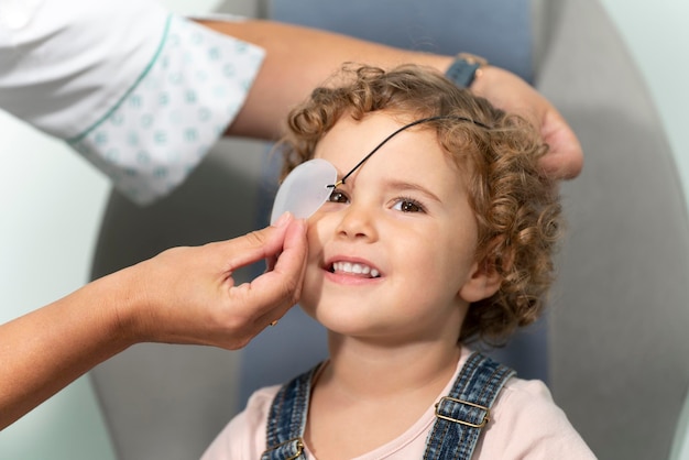 Chica de pelo rizado con un parche en el ojo en una consulta de optometristas