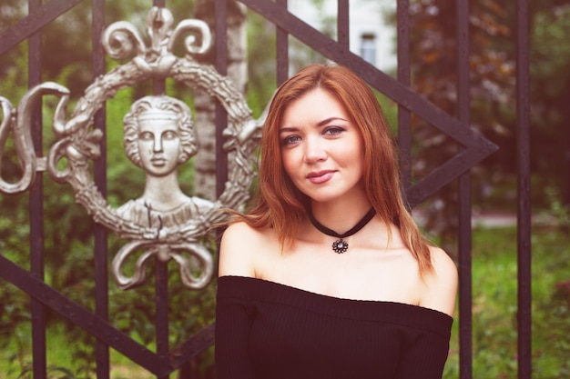 Chica con el pelo rojo con un vestido negro.