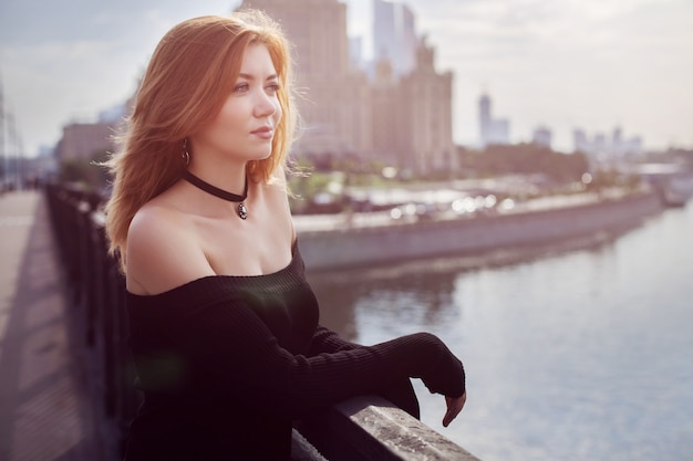 Chica con el pelo rojo con un vestido negro.