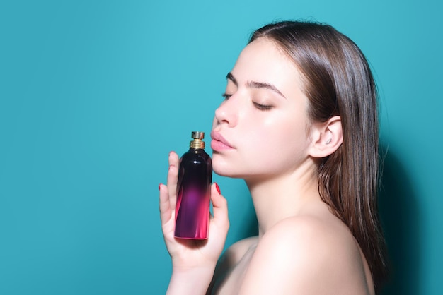 Chica con perfume joven hermosa mujer sosteniendo una botella de perfume y oliendo aroma sensual sexy gi