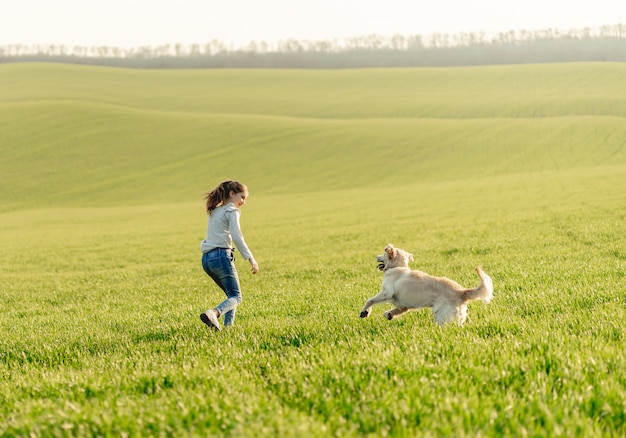 Chica con perro en campo soleado