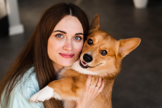 Chica y perro Corgi en casa closeup retrato Mujer joven sonrisa y abrazo Welsh Corgi Pembroke Estilo de vida con mascota doméstica