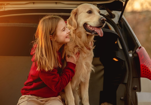 Chica con perro golden retriever en coche