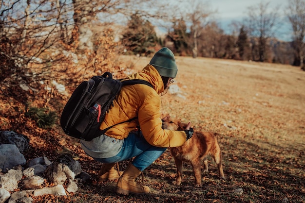 Chica con un perro juega en las montañas Estado de ánimo otoñal Viajar con una mascotaMujer y su perro posando al aire libre