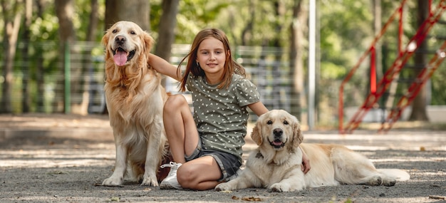 Chica con perros golden retriever