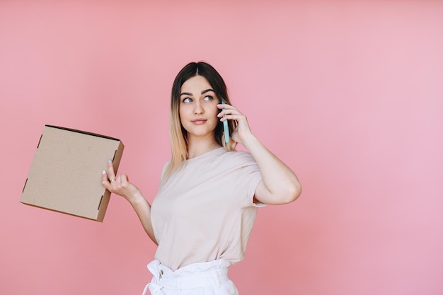 La chica pidió pizza en casa con un fondo rosa.