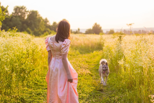 Chica de pie en el campo con un vestido rosa