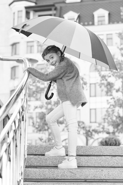 Chica de pie en las escaleras y sosteniendo un paraguas Lluvia de otoño Esperando el mal tiempo bajo el paraguas Chica elegante en el centro Positividad como resistencia al frío Hermosa dama dando un paseo