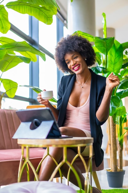 Chica de piel negra con cabello afro con un vestido rosa y chaqueta negra