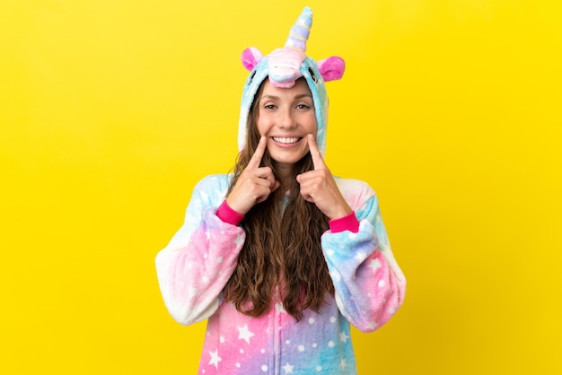 Chica con pijama de unicornio sobre fondo aislado sonriendo con una expresión feliz y agradable