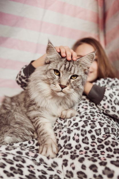 Chica en pijama y vista frontal de gato