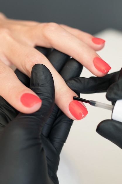 Chica pintando uñas, maestra de manicura en el trabajo