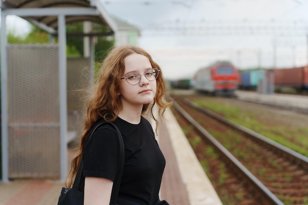 Chica en la plataforma de embarque esperando el tren