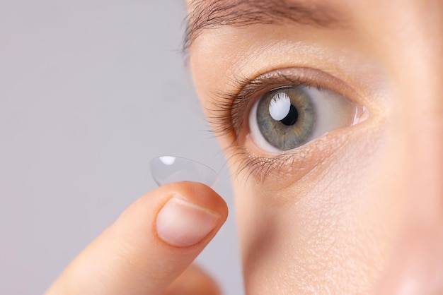 chica poniendo lentes de contacto suaves de cerca sosteniéndolas cerca de los ojos fotografía macro