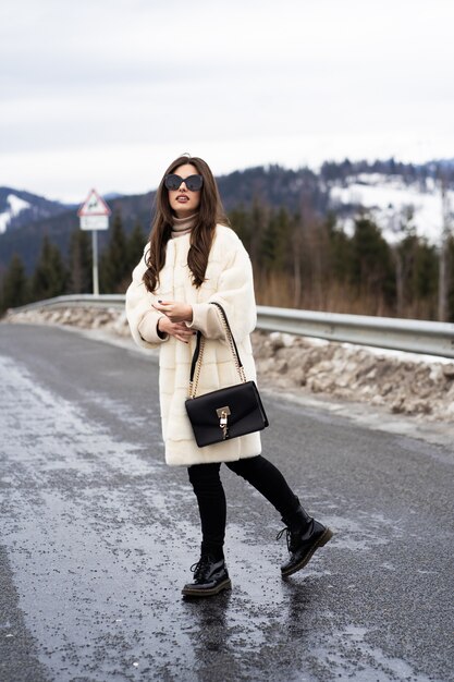 Foto chica posando en el camino en el bosque de invierno.