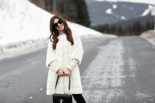 Foto chica posando en el camino en el bosque de invierno.