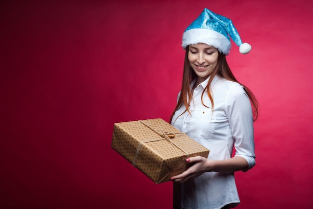 Chica posando en el estudio sobre un fondo rosa en un sombrero de NavidadxA