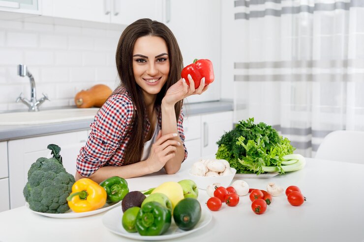 Chica posando en una mesa de cocina con pimiento
