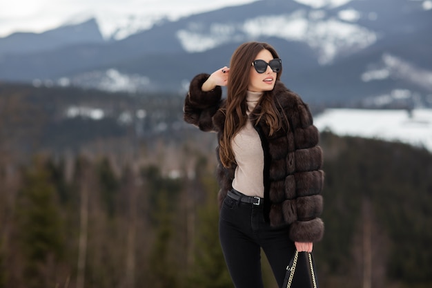 Chica posando en las montañas de invierno