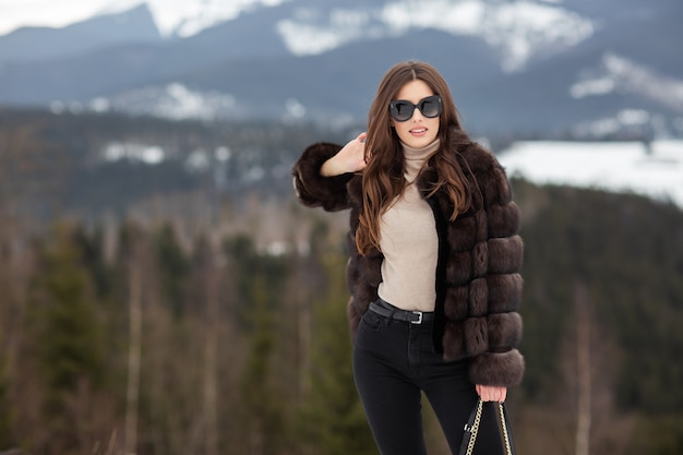 Chica posando en las montañas de invierno